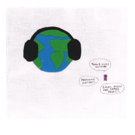 A felt depiction of the Earth wearing headphones while a small figure shouts from besides it. On a white square. The figure is shouting:
TRANS LIVES MATTER!!!
PRONOUNS MATTER!!!
EQUAL ACCESS FOR TRANS PEOPLE!!!
