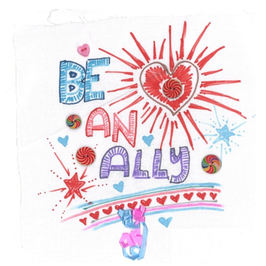 "BE AN ALLY" in big letters with a prominent shining red heart on a white square. It is decorated with swirly buttons, hearts and stars, plus some ribbon.
